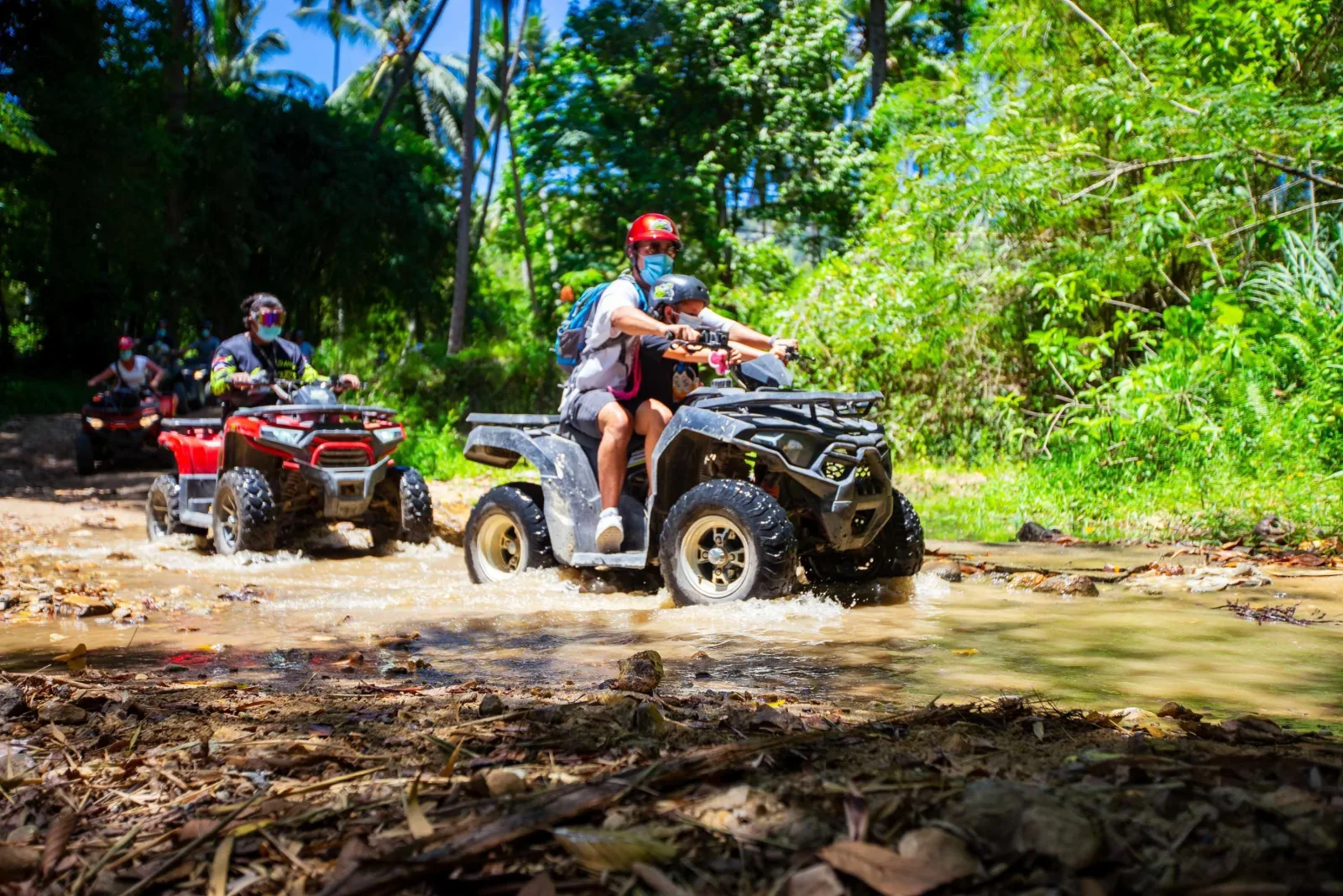 Riders in helmets and goggles on automatic quads at the Xplore base camp