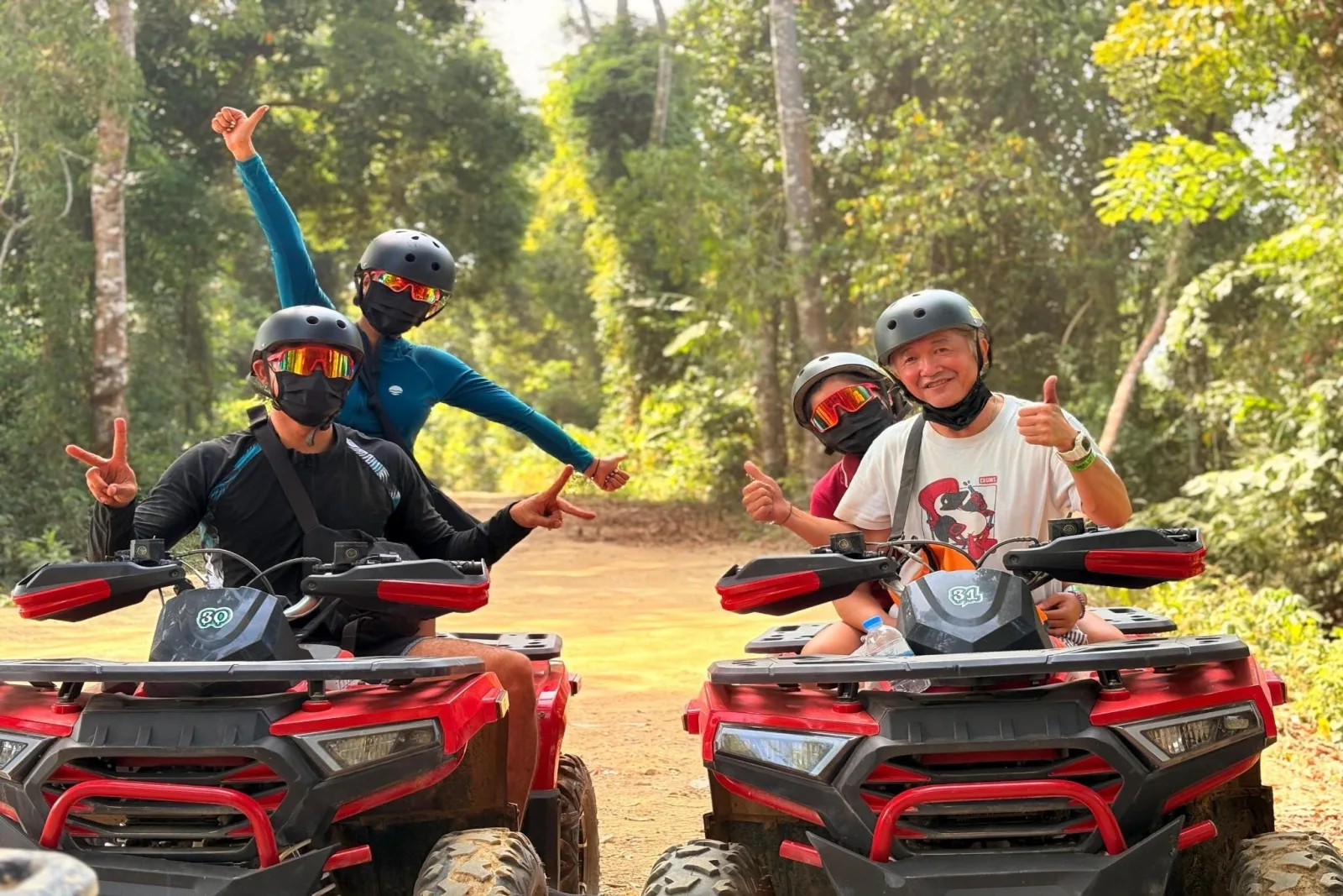 Two ATVs carrying rider-and-passenger pairs on a jungle trail on Koh Samui