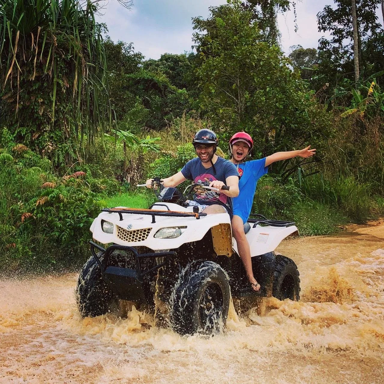 Two riders on one quad bike on a dirt track above Maenam, Koh Samui