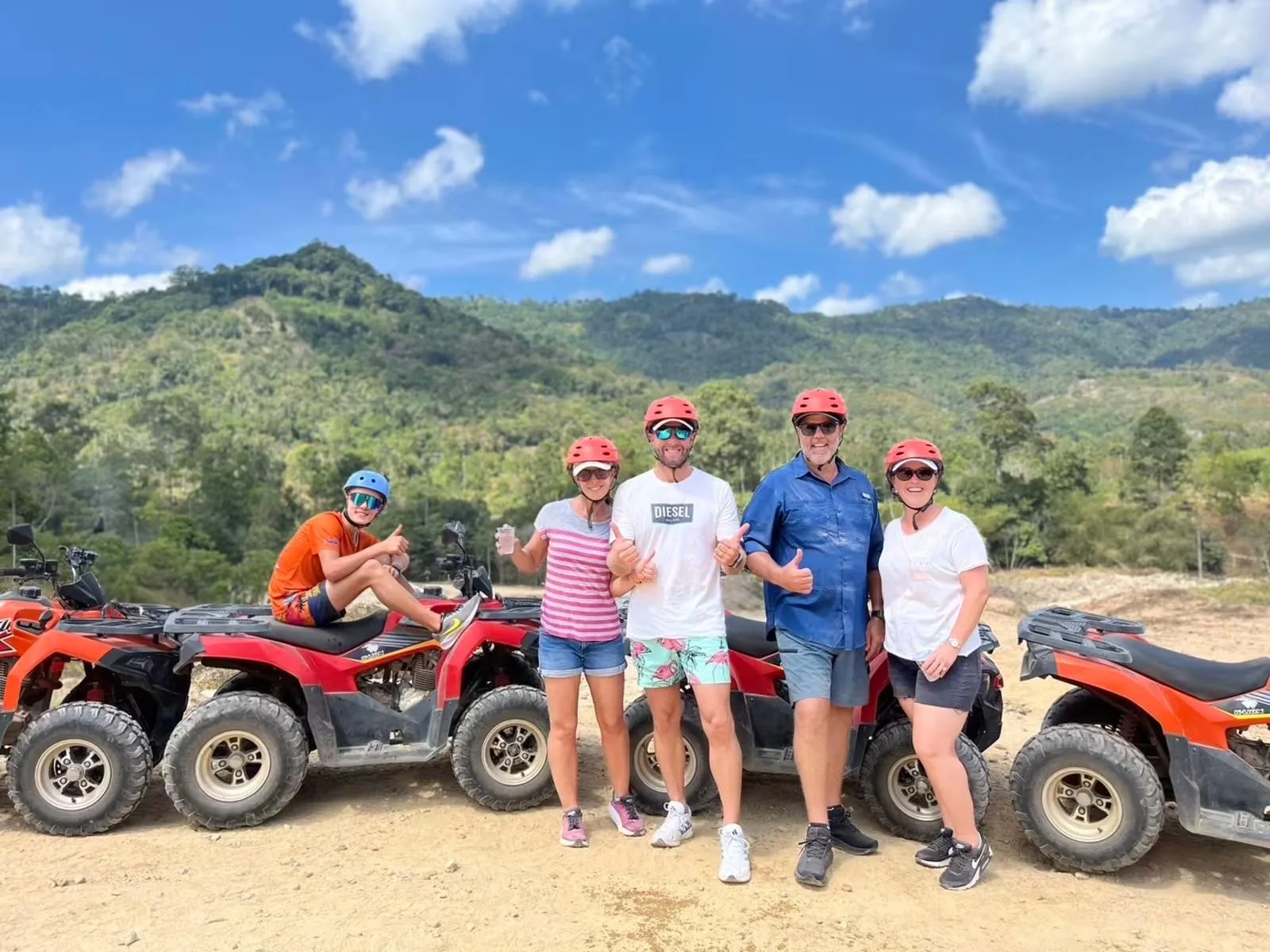 Small group of ATV riders and quad bikes with the Koh Samui mountains behind them